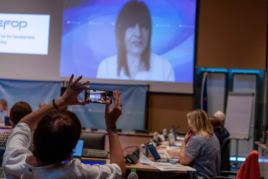 Participant taking a photo with her mobile of Mara Brugia, Cedefop Deputy Director, giving an online presentation at the 4th policy learning forum on learning outcomes