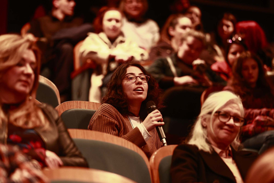 Girl asking a question, people in screening room