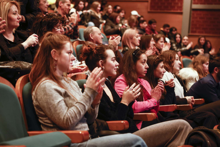 Audience in a screening room clapping hands