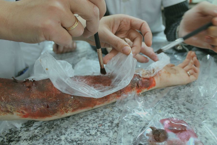 Students using makeup to create wound-like skin